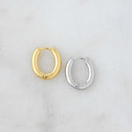 Gold and silver huggie hoop earrings side by side.