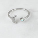 Upclose shot of sterling silver adjustable moon ring with opal stone.