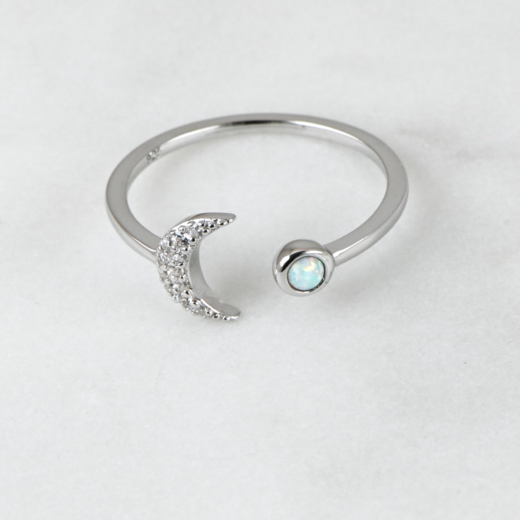 Upclose shot of sterling silver adjustable moon ring with opal stone.