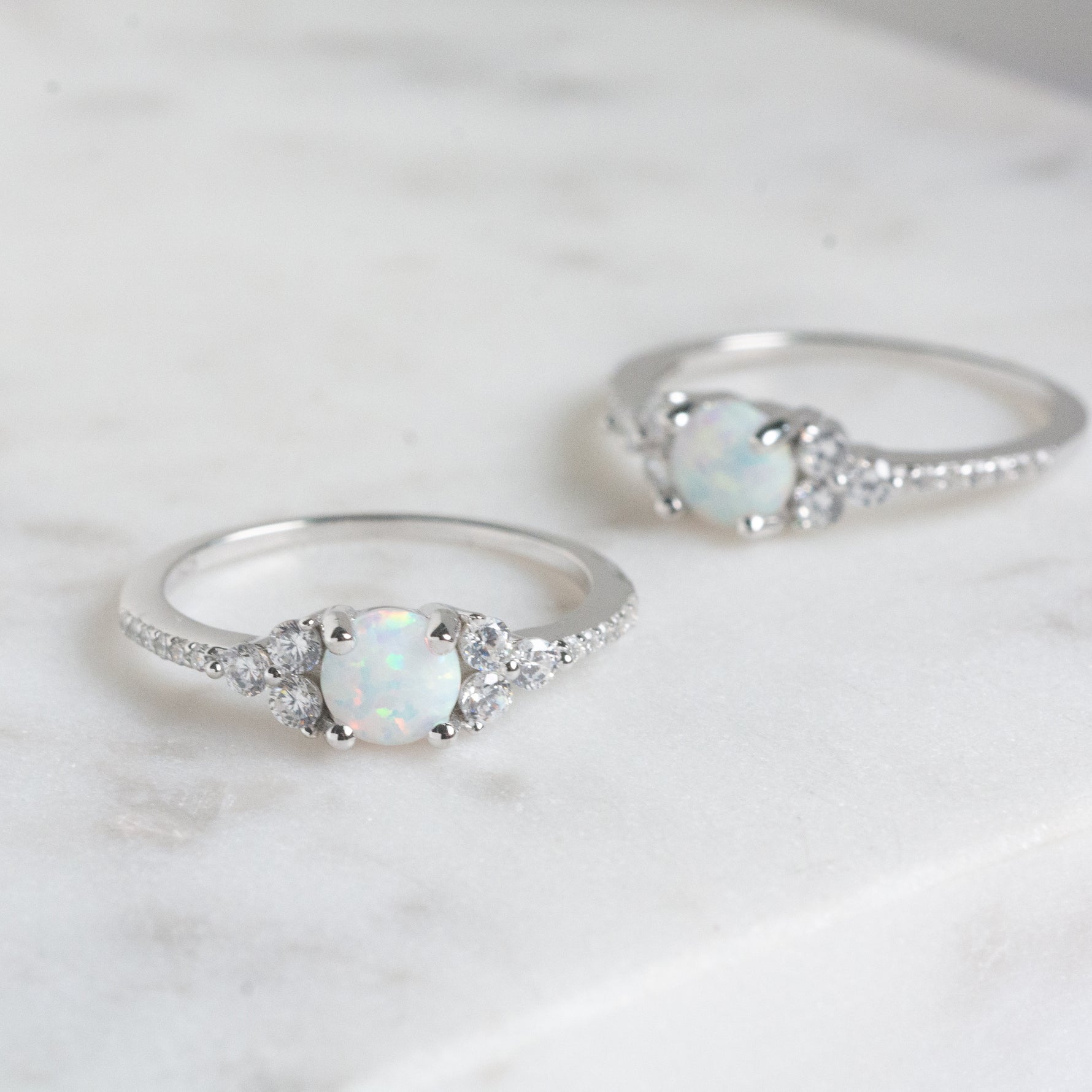 Delicate silver opal stone with cz diamonds surrounding the gemstone ring.