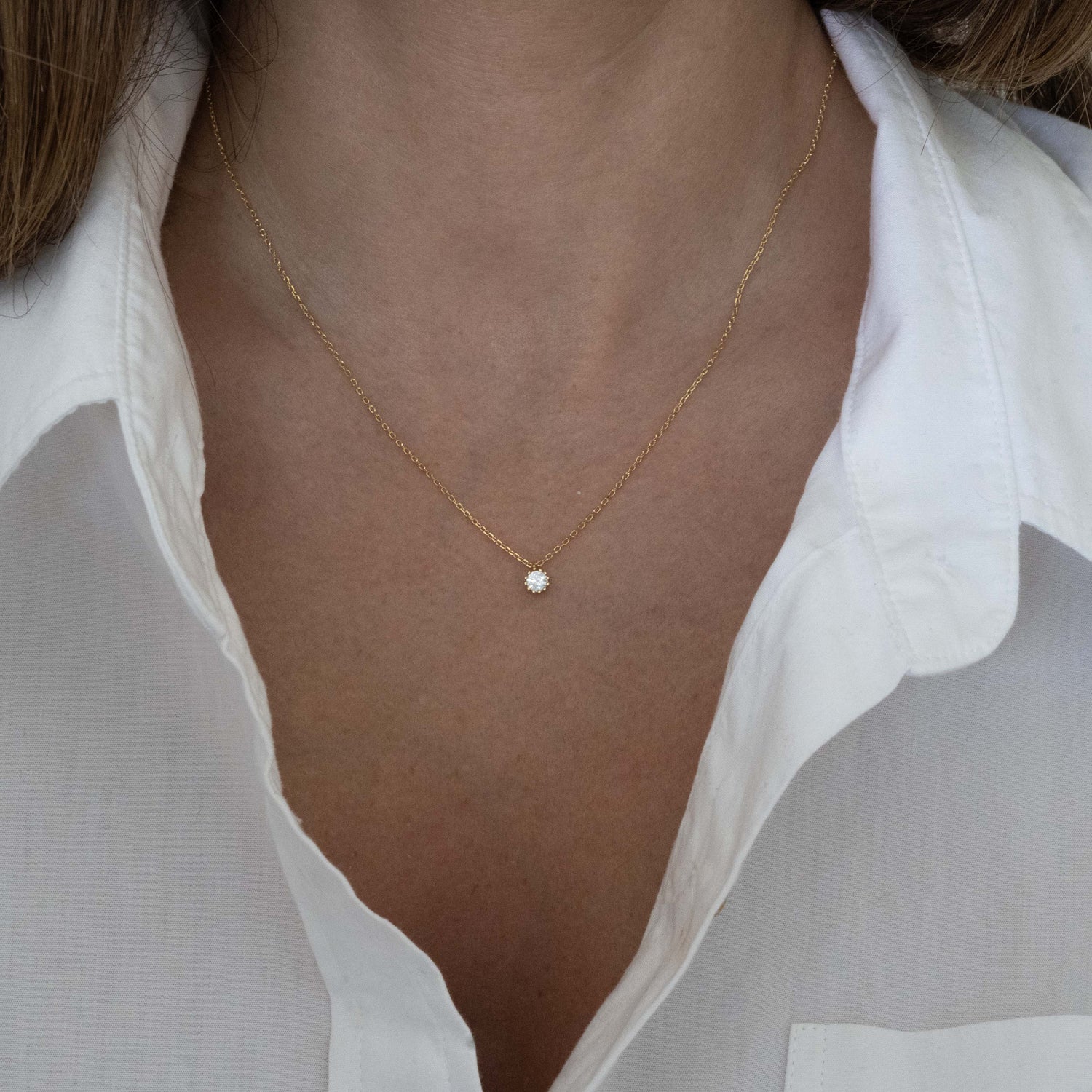 model wearing dainty everyday gold round bezel pendant necklace