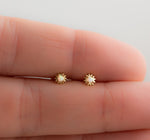 Model wearing delicate gold opal celestial stud earrings. 