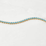Upclose shot of gold beachy turquoise tennis anklet