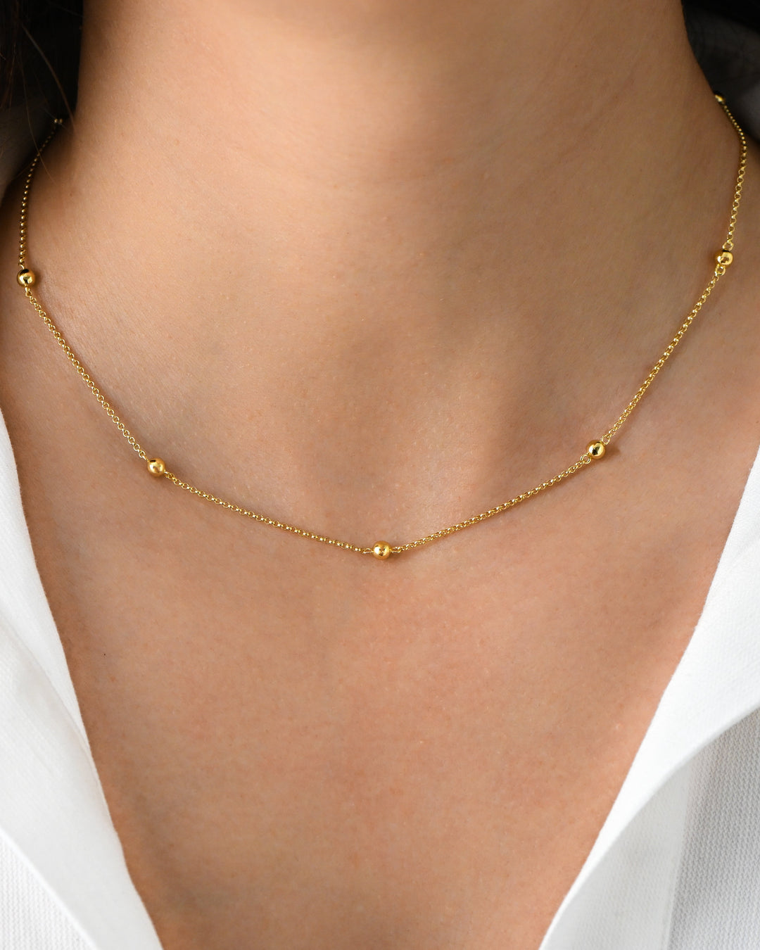 Gold beaded necklace on model 