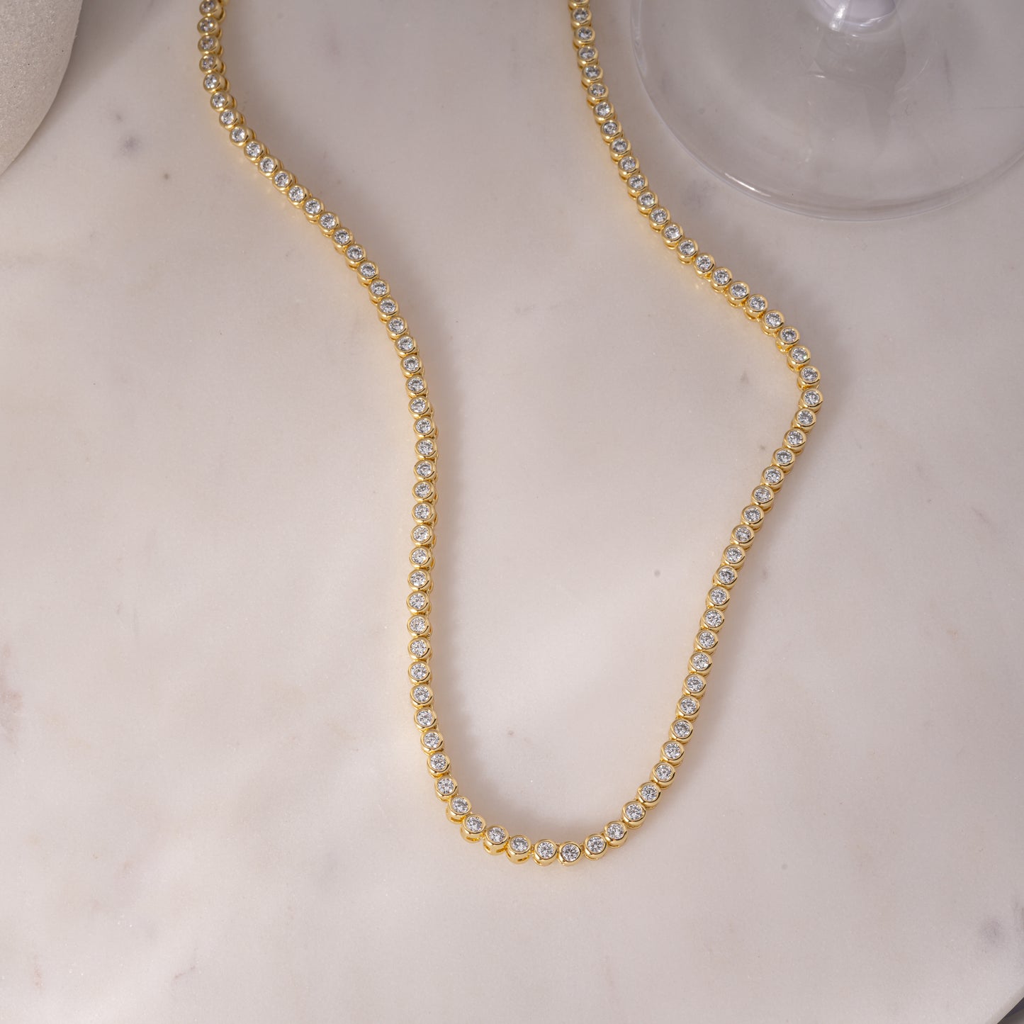 a white marble table with a gold necklace on it