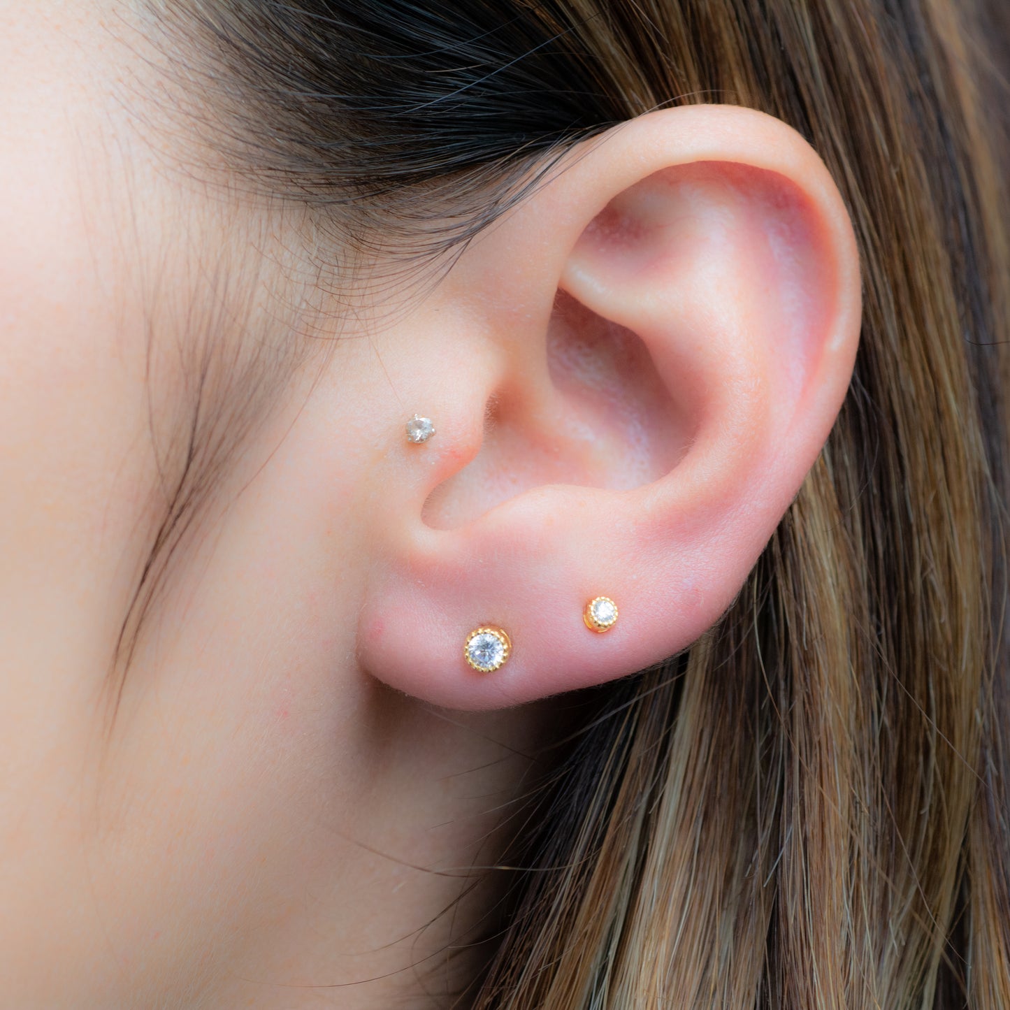 model wearing Minimalist diamond stud earrings on second piercing. 