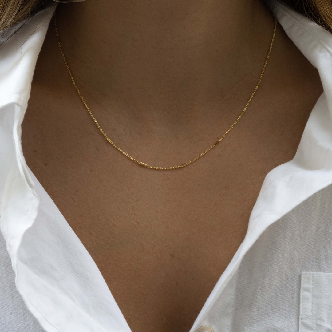model wearing dainty layering necklace in gold 