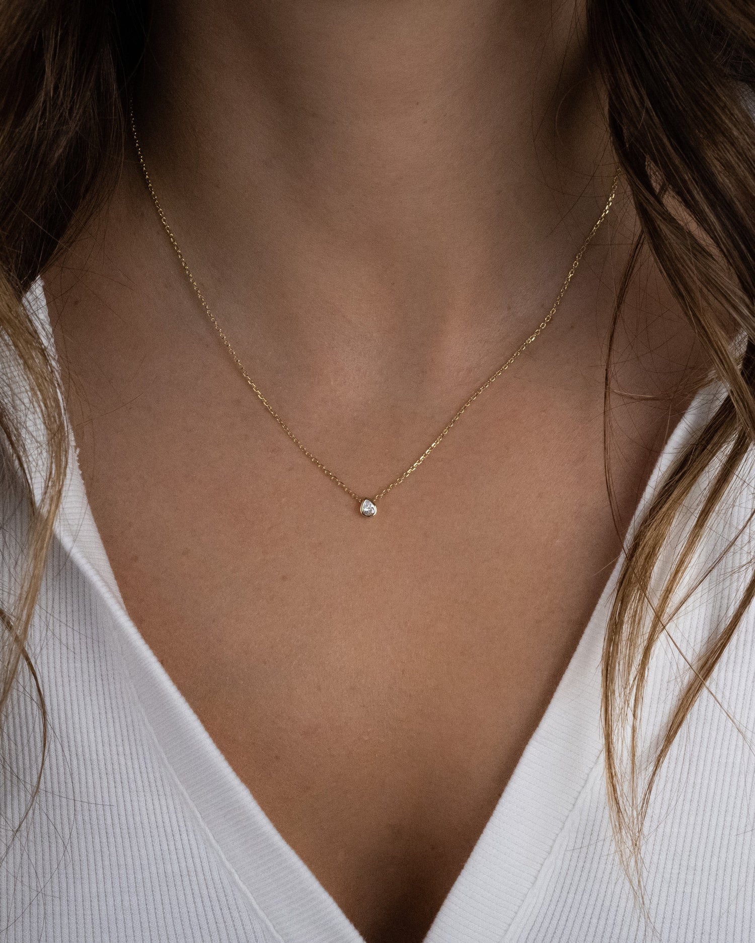 Model wearing dainty gold pear necklace 