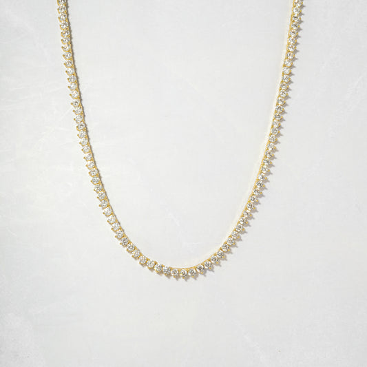 a gold necklace with white stones on a white background