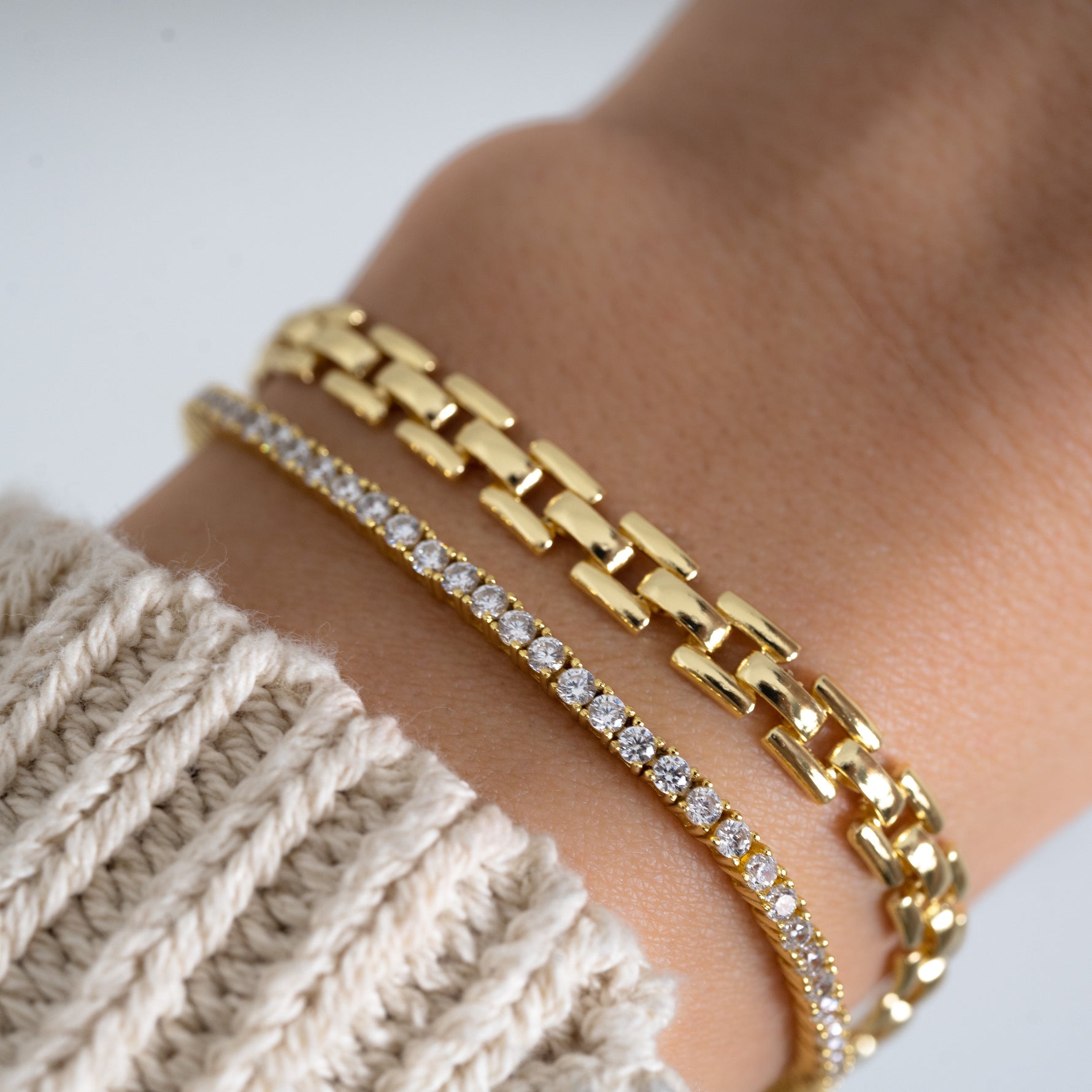 Tennis bracelet and gold chain bracelet on female model