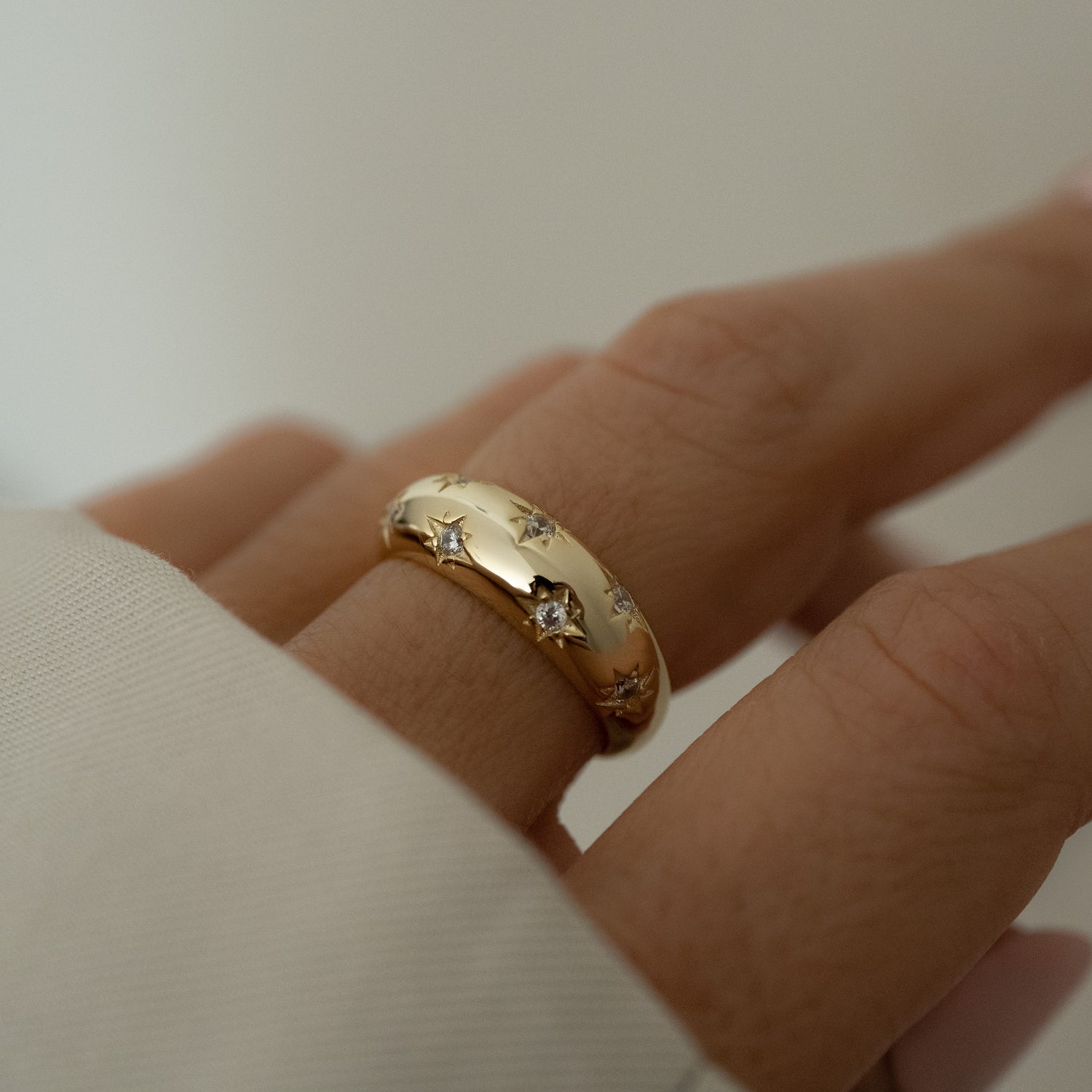 Dome ring with tiny CZ stars in 14k gold plated sterling silver, showcased on model for a chic look