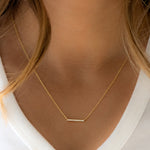 Model wearing gold bar pendant necklace
