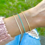 Model wearing dainty colorful Tennis Bracelets stacked together, with cz stones, turquoise stones and silver cz stones.