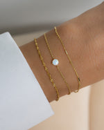model wearing delicate bracelet set featuring an opal stacking bracelet