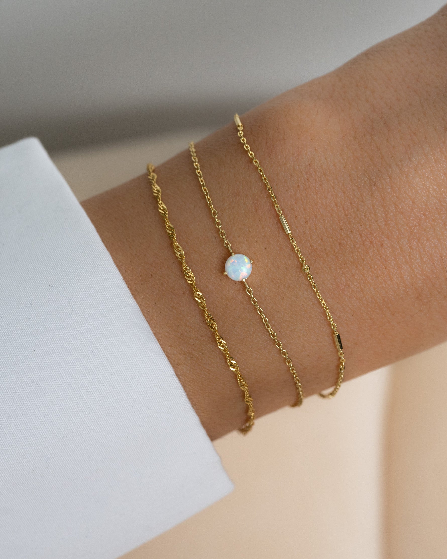model wearing delicate bracelet set featuring an opal stacking bracelet