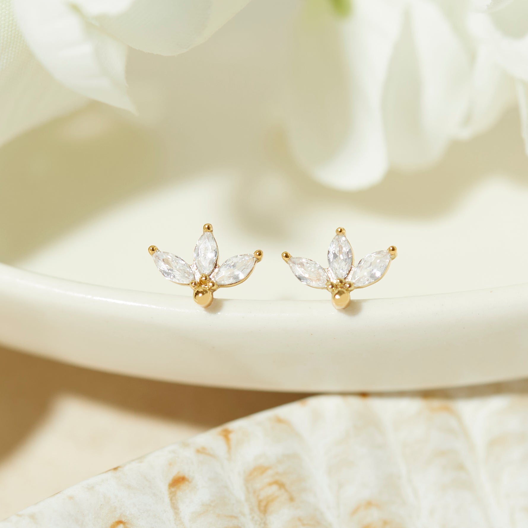 closeup image of gold petal stud earrings