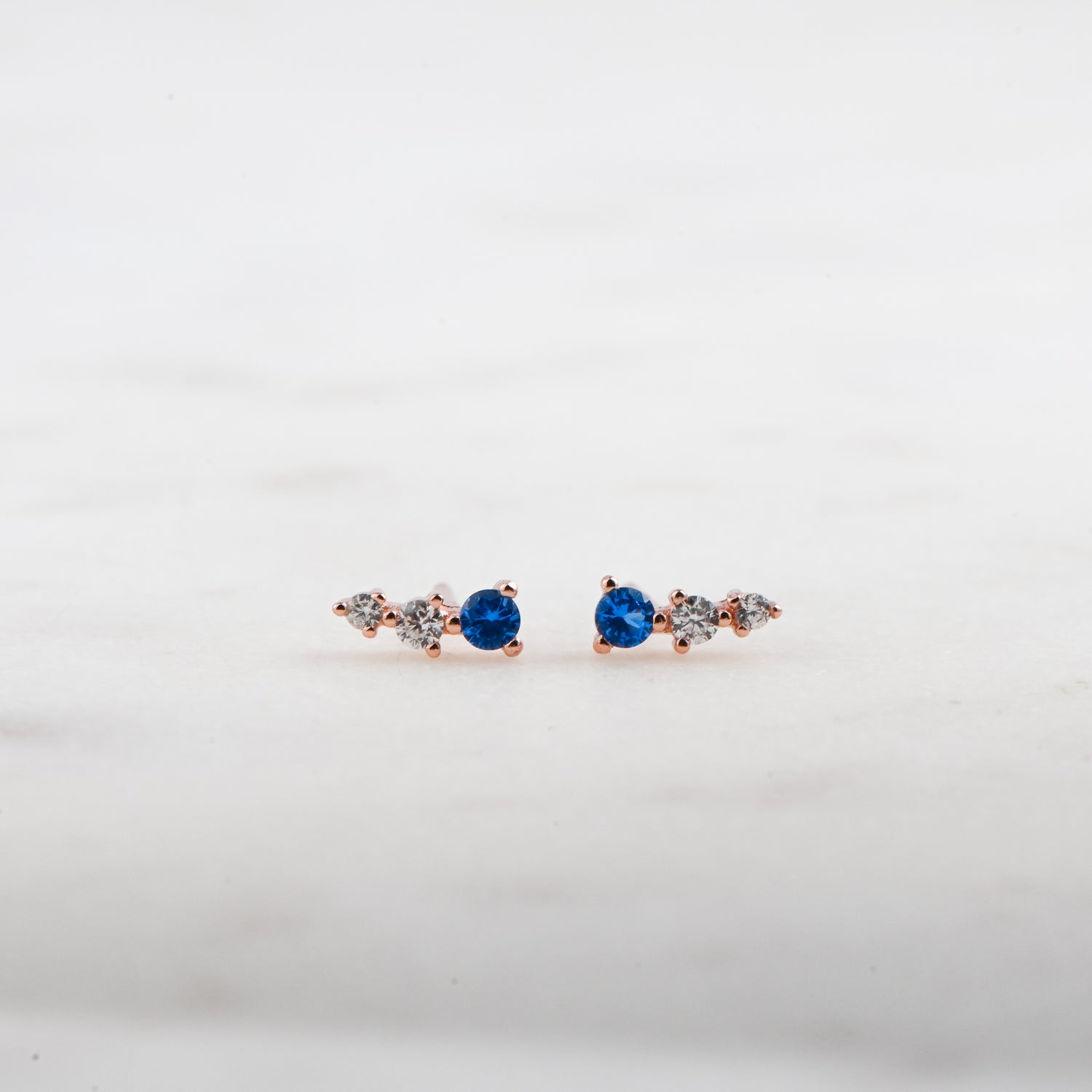 Rose gold ear climber studs with sapphire and diamond stones.