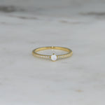 closeup image of dainty opal ring with pave cubic zirconia stones