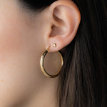 Madison Beer wearing gold hoop earrings and dot stud earrings