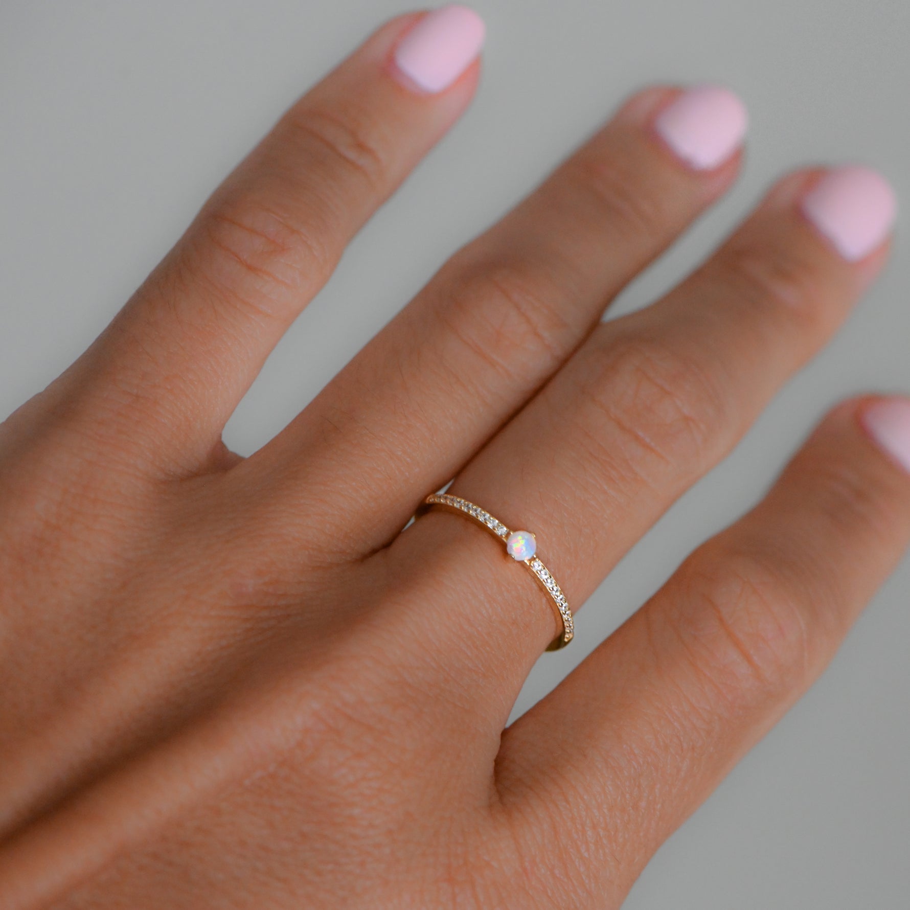 closeup image of opal stacking ring with cubic zirconia stones