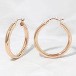 Madison beer inspired rose gold hoop earrings on a marble background