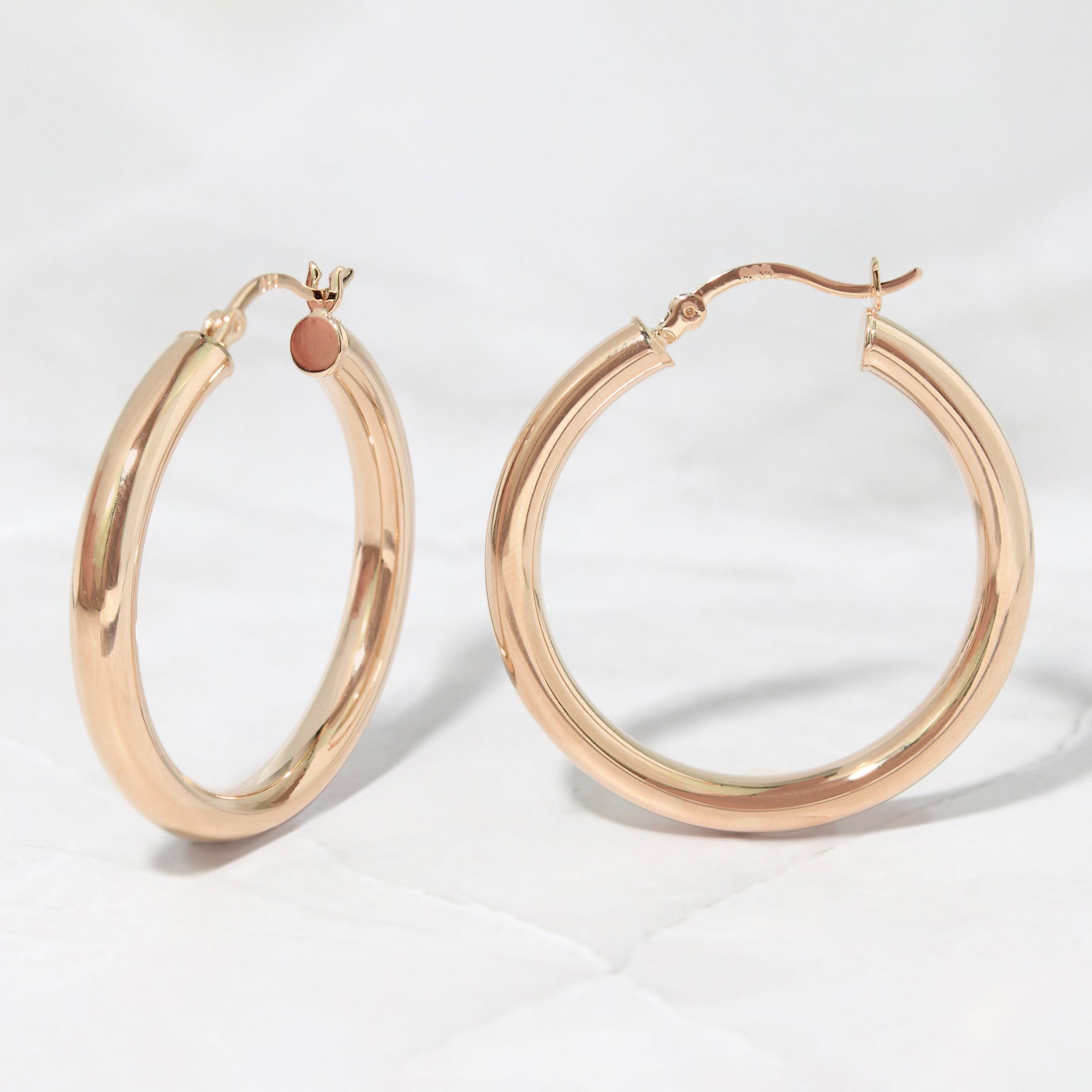 Madison beer inspired rose gold hoop earrings on a marble background