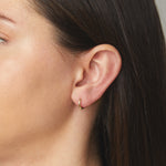 model wearing simple huggie hoop earring