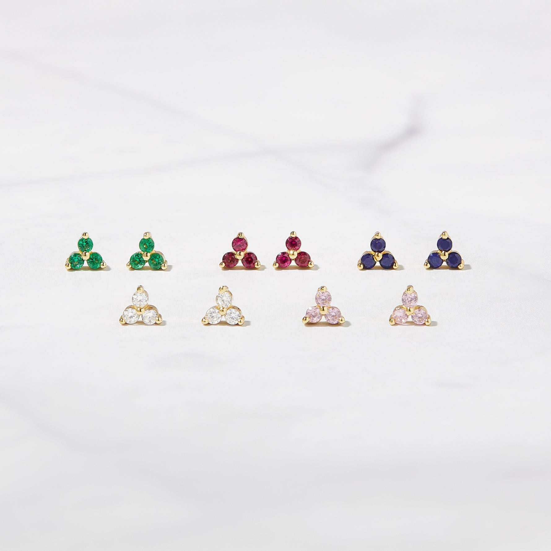 Image of 3 stone cz stud earrings in emerald, ruby, sapphire, white diamond, and pink