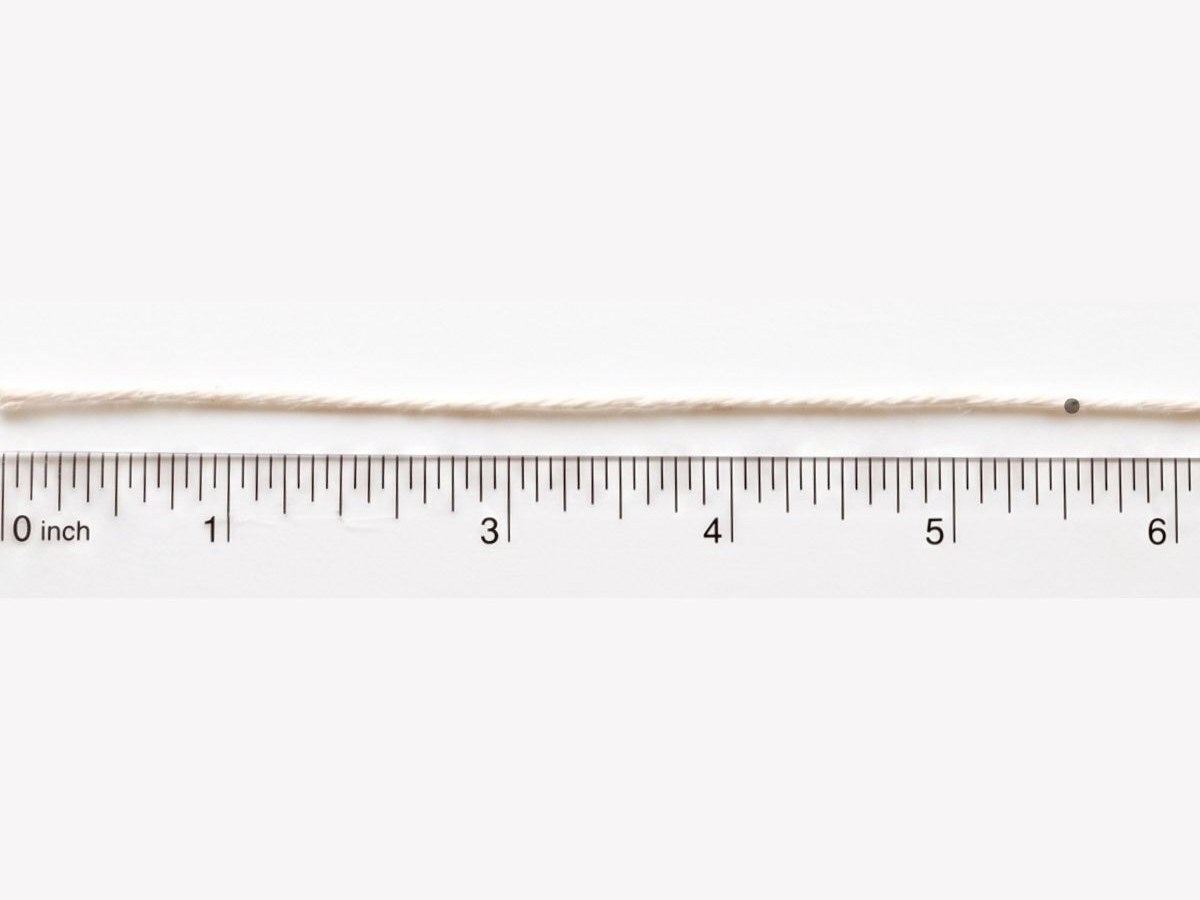 The marked string laid flat against a ruler showing the measurement in inches